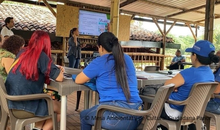 Tres mujeres sentadas dando la espalda atentas a una charla