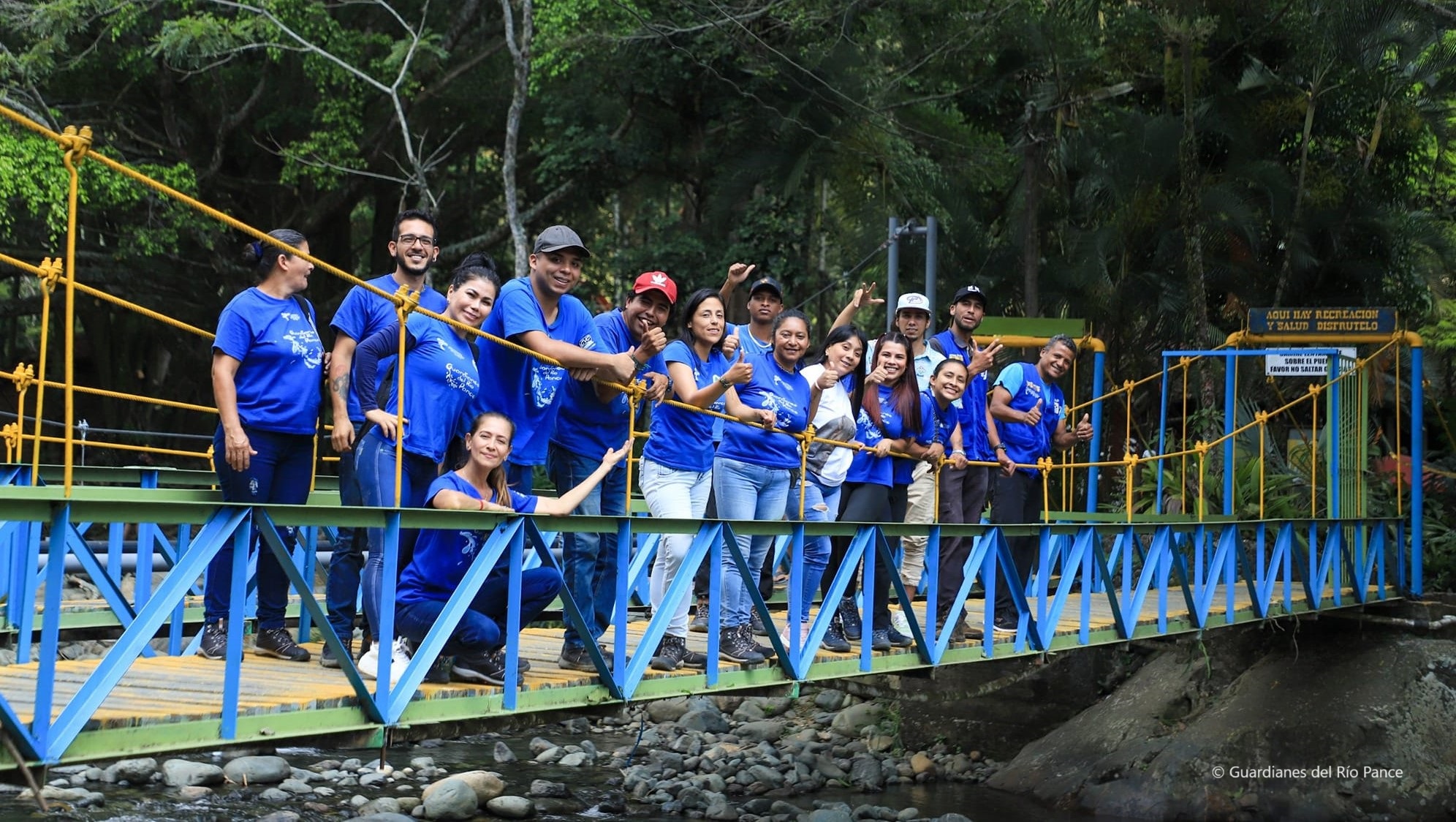 Grupo de personas en un puente que visten camisetas de color azul